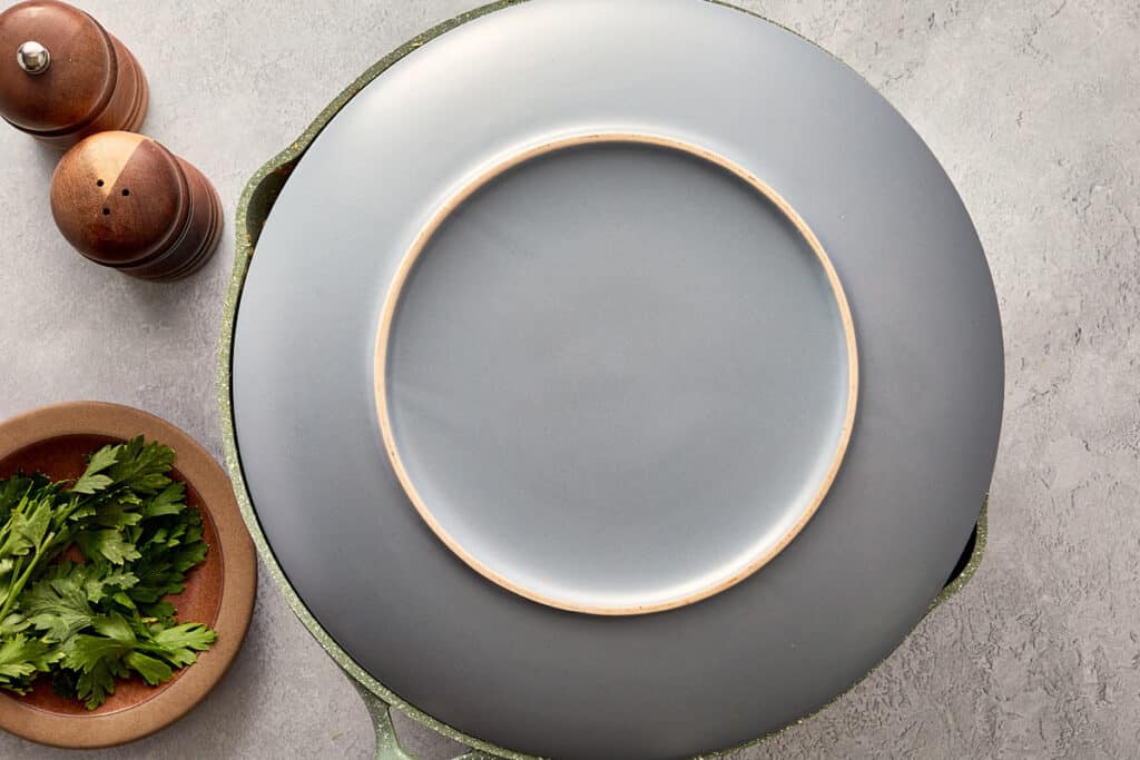 Plate placed over pan ready to flip tortilla española