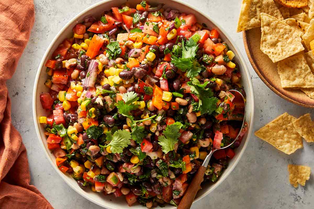 Easy black eyed pea salad served in a bowl with fresh coriander and tortilla chips on the side.