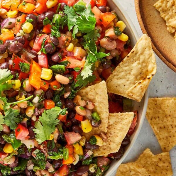 Easy black eyed pea salad with black beans, corn, tomatoes, jalapeños and fresh coriander served with tortilla chips.