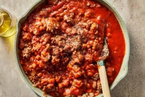 Thick beef and tomato sauce simmering in a skillet for cabbage lasagna.