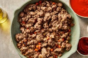 Browned ground beef cooked with vegetables in a skillet.