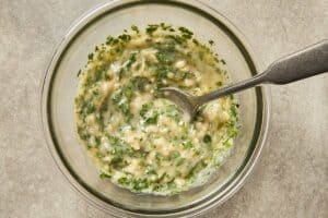 Garlic butter mixture with parsley prepared for cheesy garlic rolls