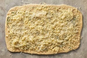 Garlic butter spread evenly over rolled dough with mozarella and parm