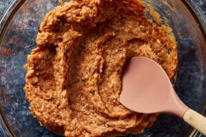 Fully mixed, seasoned ground meat in a glass bowl.