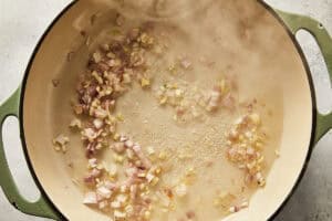 Chopped shallots and garlic sizzling and steaming as the vodka reduces at the bottom of the pot.