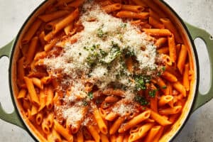 Cooked one-pot spicy vodka pasta topped with a generous mound of grated pecorino cheese and chopped fresh basil.