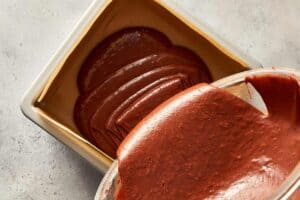 Pouring the brownie batter into the prepared baking pan