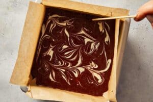 Drizzling the white chocolate melted on top and using a knife swirl the chocolate to make beautiful wave patterns.