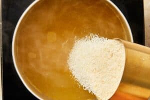 Chicken stock boiling while adding the grits to the pot