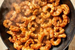 shrimp being cooked in the same pan as the bacon