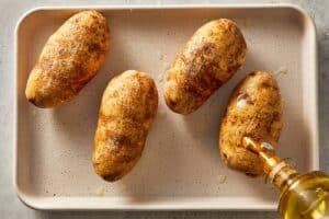 Potatoes being drizzled with olive oil