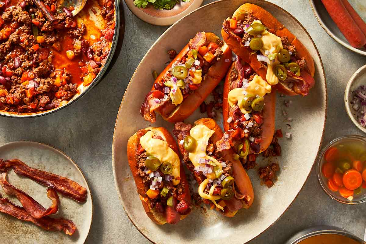 putting toppings in the chili dogs