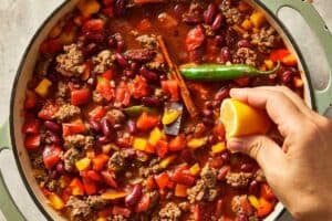 squeezing lemon in the pan with beef and aromatics