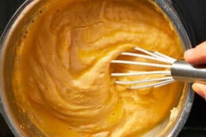 cheddar sauce being mixed in a pan