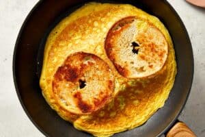 eggs and bagels being cooked in a pan