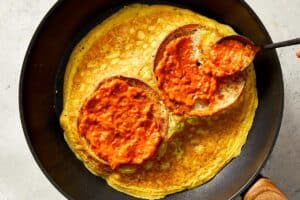 Spreading the tomato sauce in the bagels