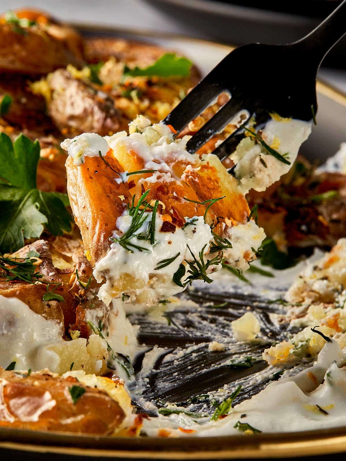 fork holding finished smashed potatoes with lemon and whipped cream