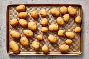 Potatoes in the baking sheet ready to be pressed