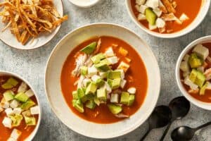avocado, soup, cheese and chicken in a plate for serving