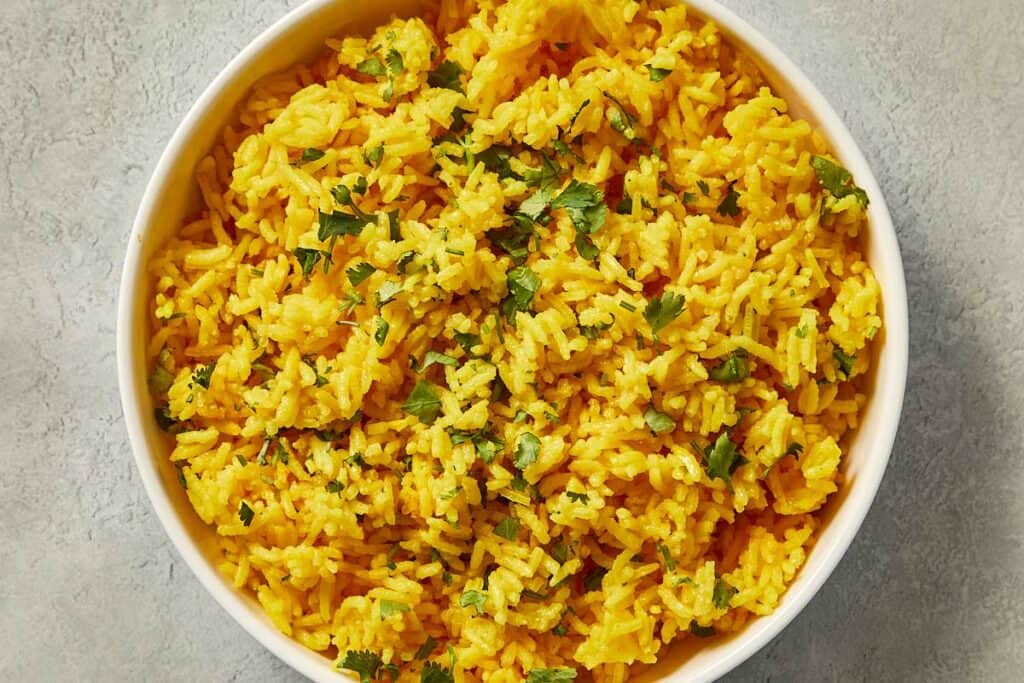 Yellow turmeric rice mixed with fresh chopped cilantro.