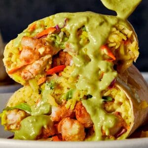 Close Up of Shrimp Burrito being drizzled with salsa verde