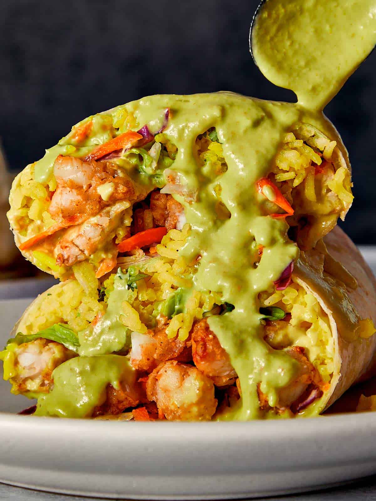 Close Up of Shrimp Burrito being drizzled with salsa verde