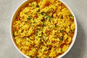 Yellow turmeric rice mixed with fresh chopped cilantro.